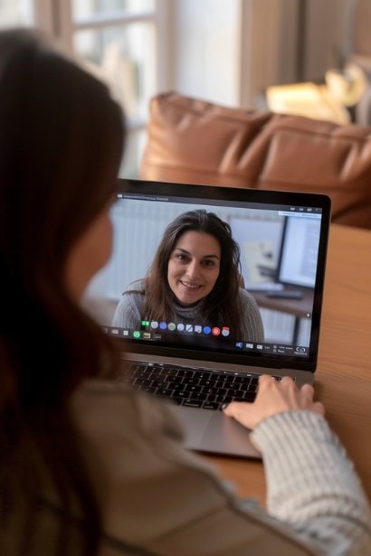 A young female professional, looking enthusiastic and expectant, participating in a video call interview on her laptop. The screen displays a friendly and professional greeting from the interviewer, symbolizing the beginning stages of the hiring process. Her prepared and hopeful expression, along with the modern, digital interview setup, reflects the evolving nature of candidate attraction and interviewing techniques.