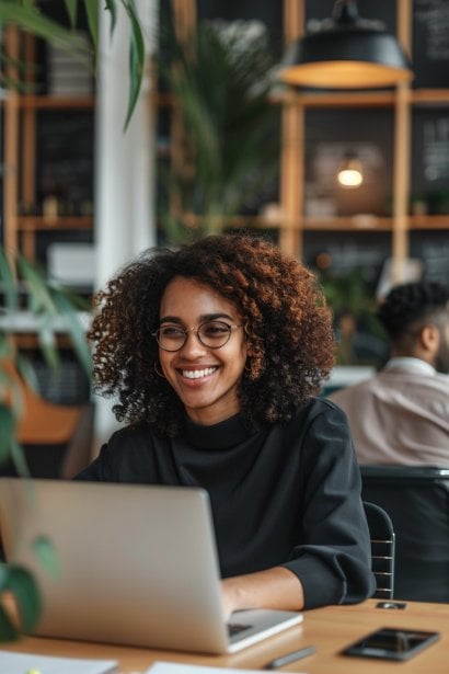 A modern, bright workspace with a female professional conducting a video call on her laptop with a male colleague from a different cultural background. They're both smiling and engaging warmly, illustrating cross-cultural empathy and the importance of digital communication in bridging global divides.