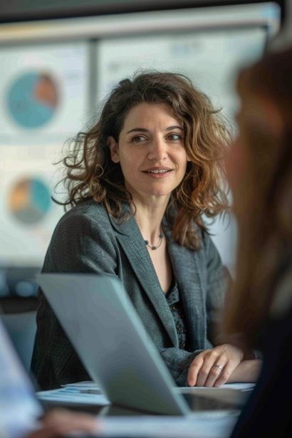 A female manager, looking strategic and focused, leading a training session in a conference room. She’s demonstrating the use of a CRM tool on a screen to a small group of attentive employees, emphasizing the practical application of a missed call strategy.